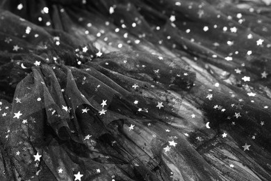 Photo of Beautiful black tulle fabric with shiny stars as background, closeup