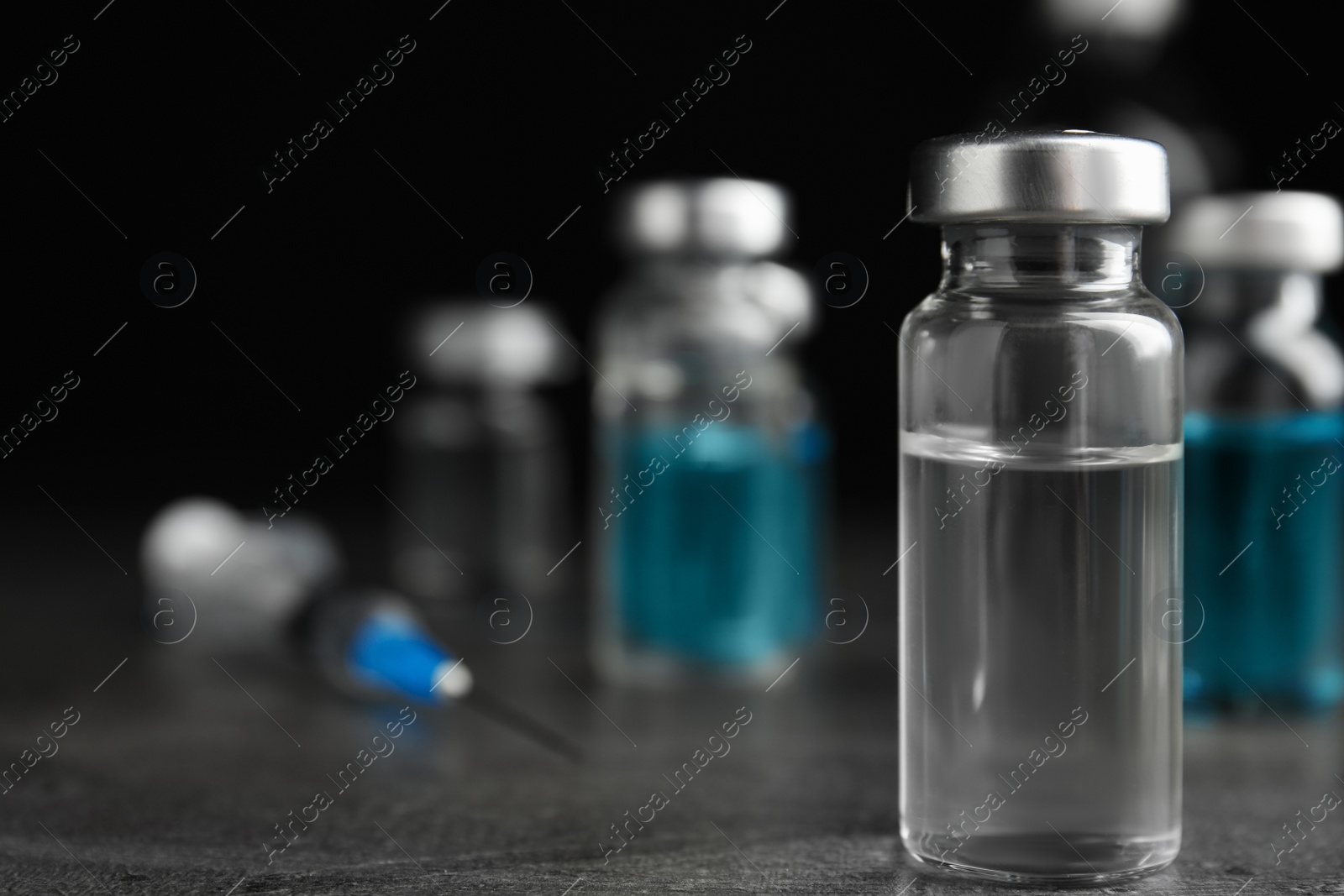 Photo of Vial with medication on grey table, space for text. Vaccination and immunization