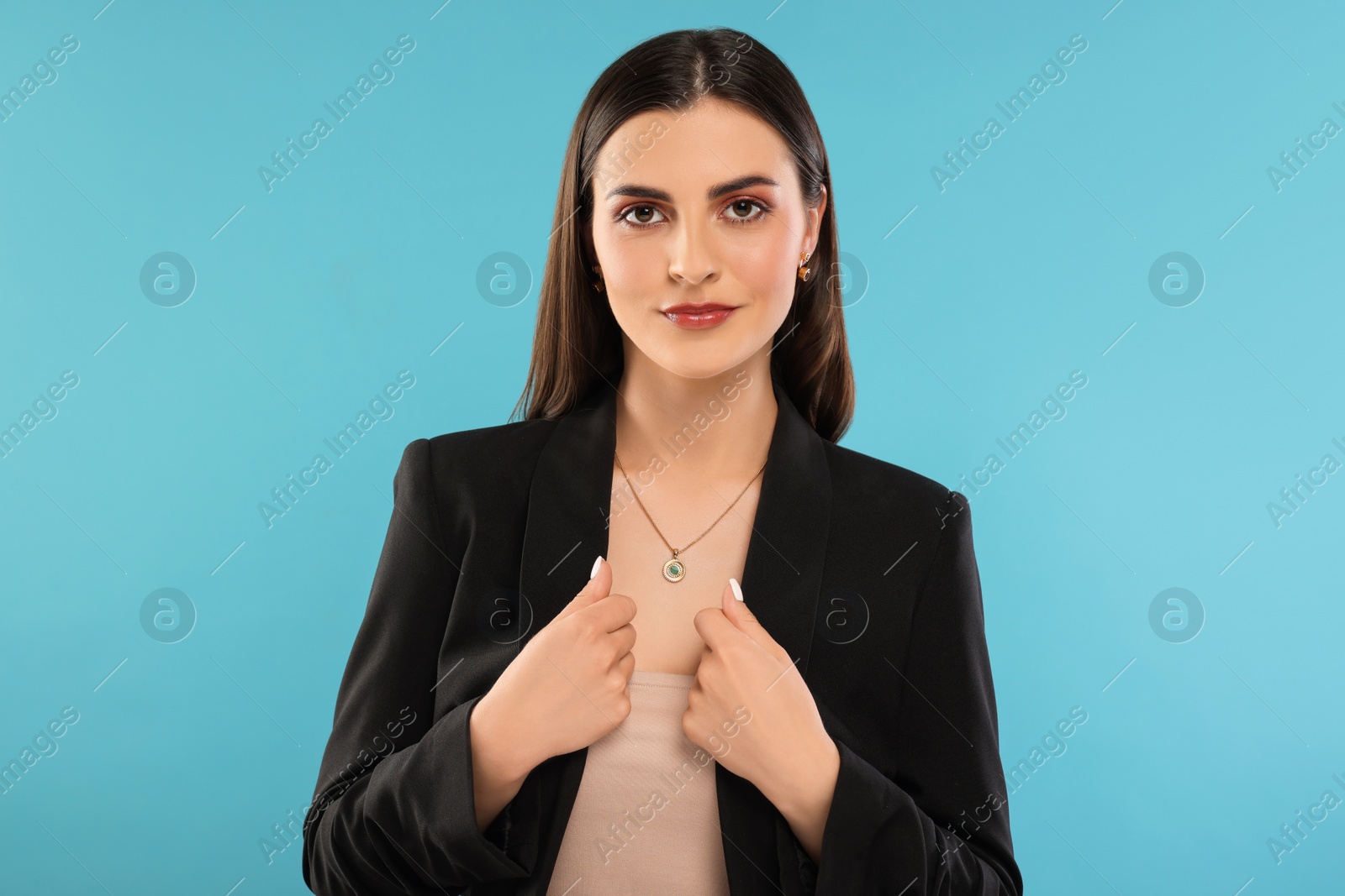 Photo of Beautiful woman with elegant jewelry on light blue background