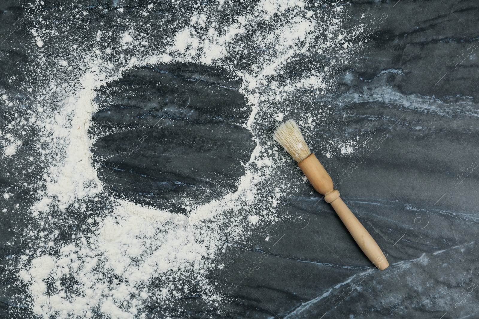 Photo of Flour and brush on grey marble background, flat lay. Space for text