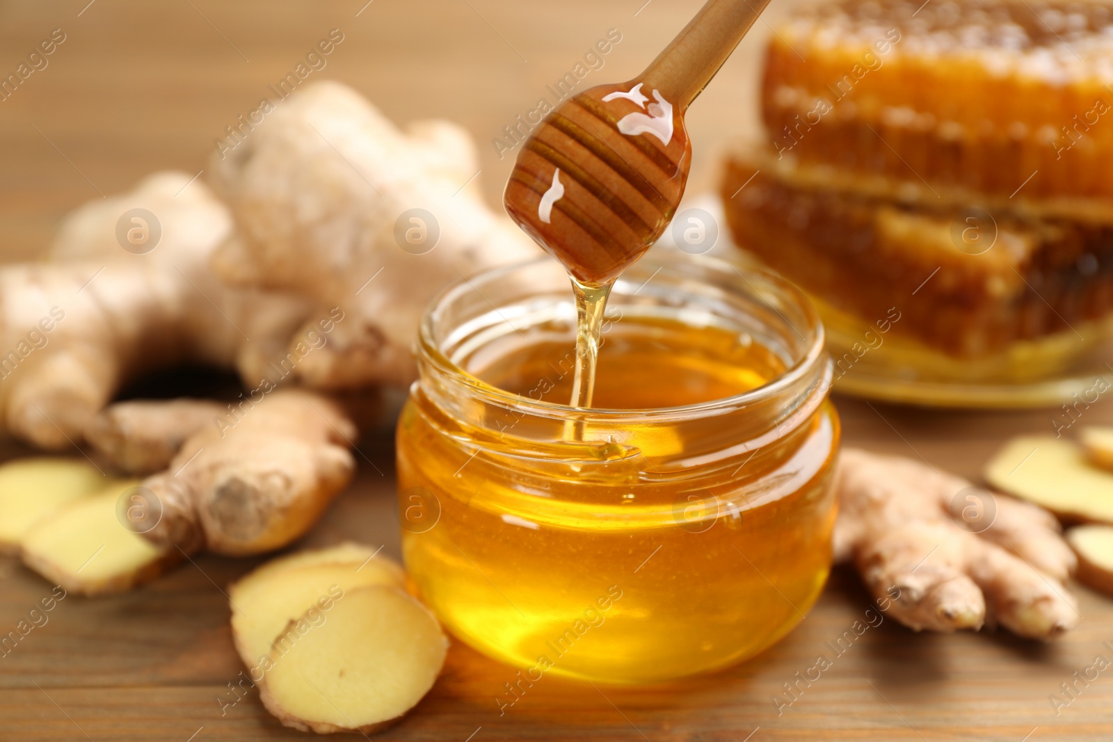 Photo of Honey and ginger on wooden table. Natural cold remedies