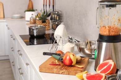 Modern mixer, blender and different ingredients on white marble countertop in kitchen, space for text