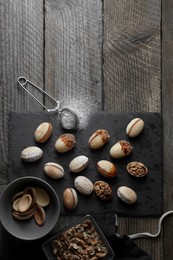 Freshly baked homemade walnut shaped cookies, nuts and flour on wooden table, flat lay. Space for text