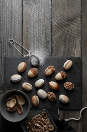 Photo of Freshly baked homemade walnut shaped cookies, nuts and flour on wooden table, flat lay. Space for text