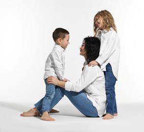 Photo of Little children with their mother on white background