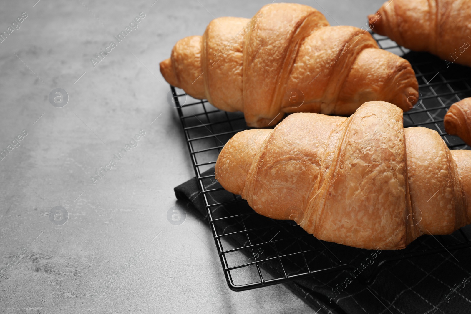 Photo of Tasty fresh croissants on light grey table, closeup