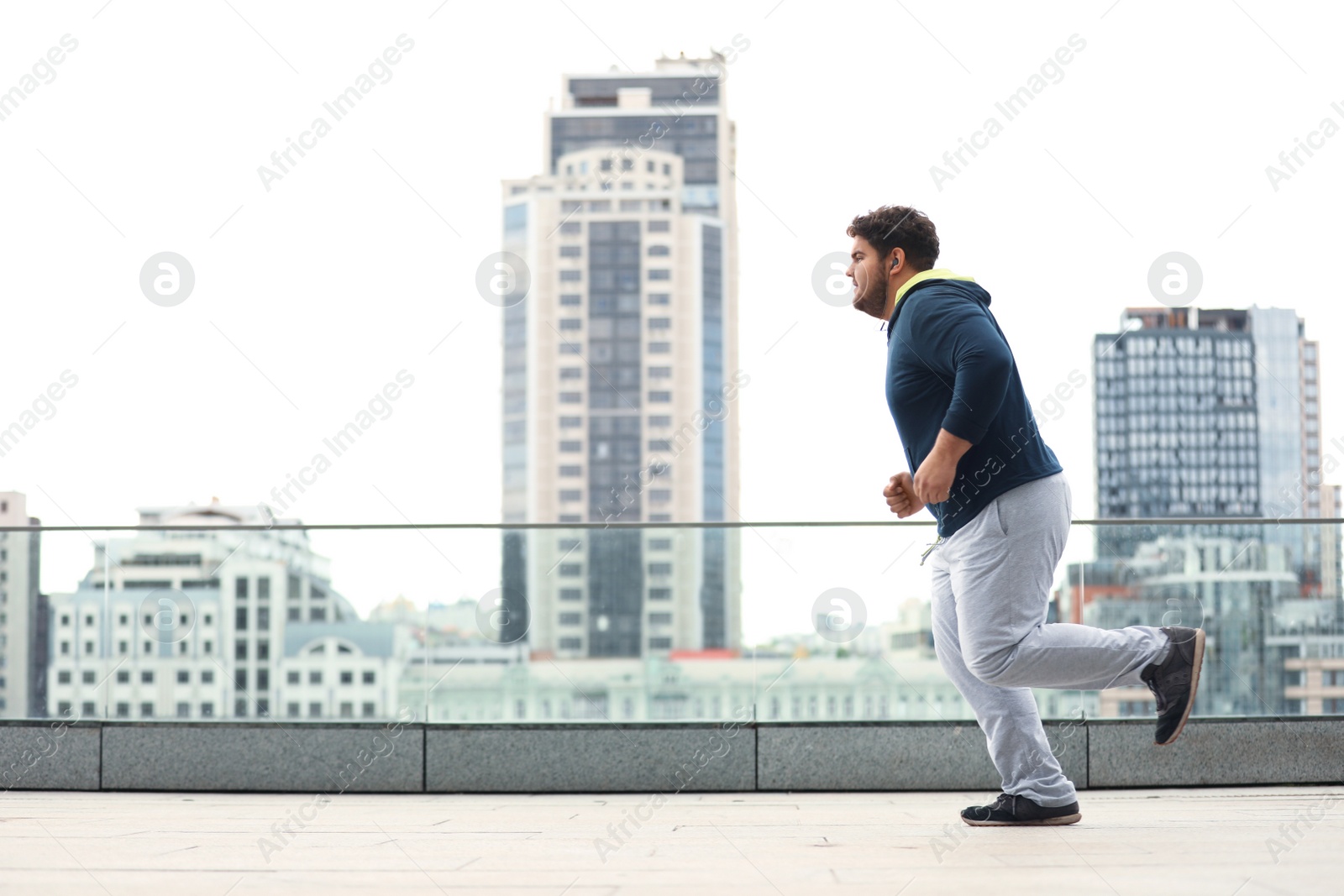 Photo of Young overweight man running outdoors. Fitness lifestyle