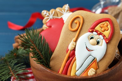 Tasty gingerbread cookies and fir branch in bowl, closeup. St. Nicholas Day celebration