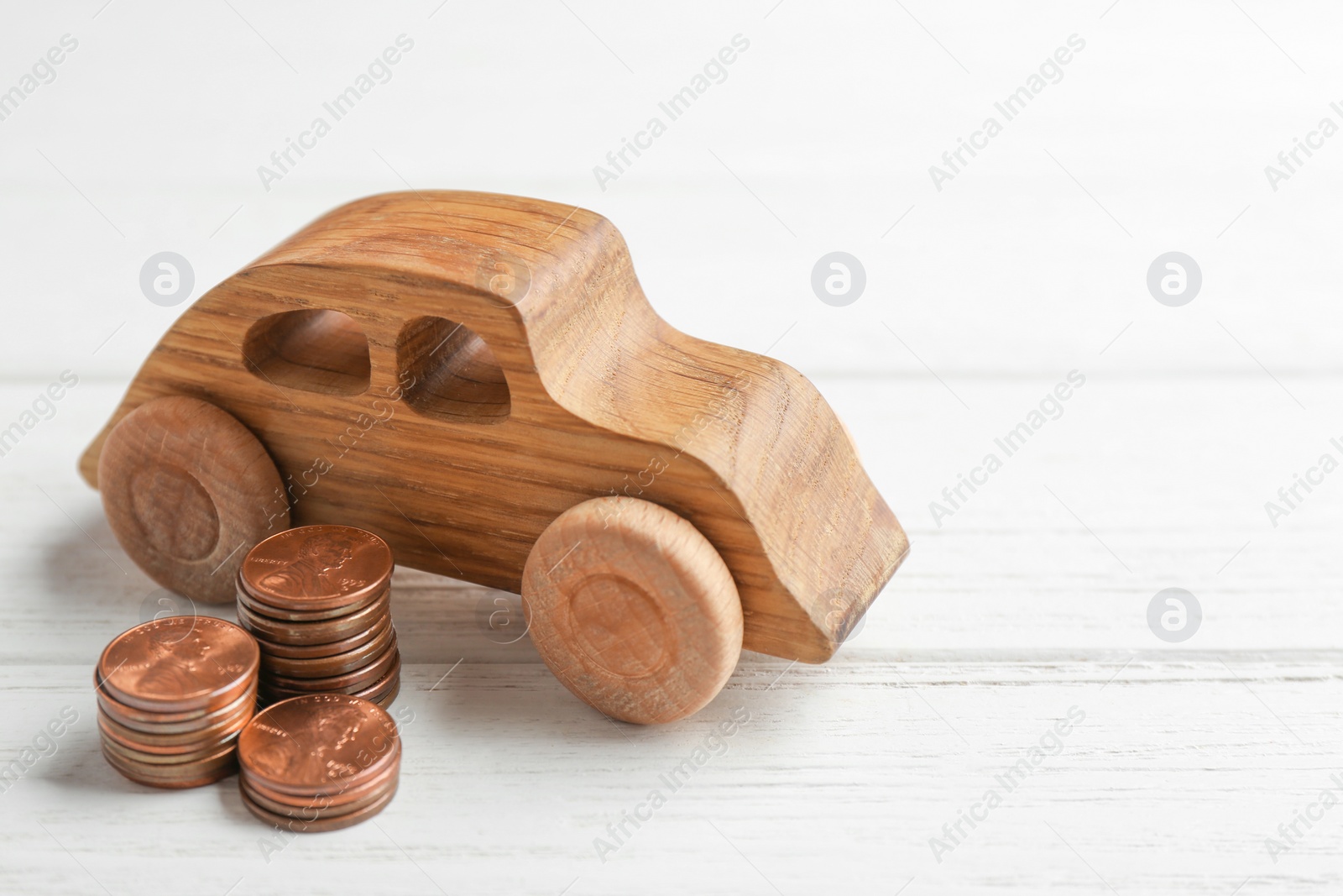 Photo of Car model and coins on white wooden background. Space for text