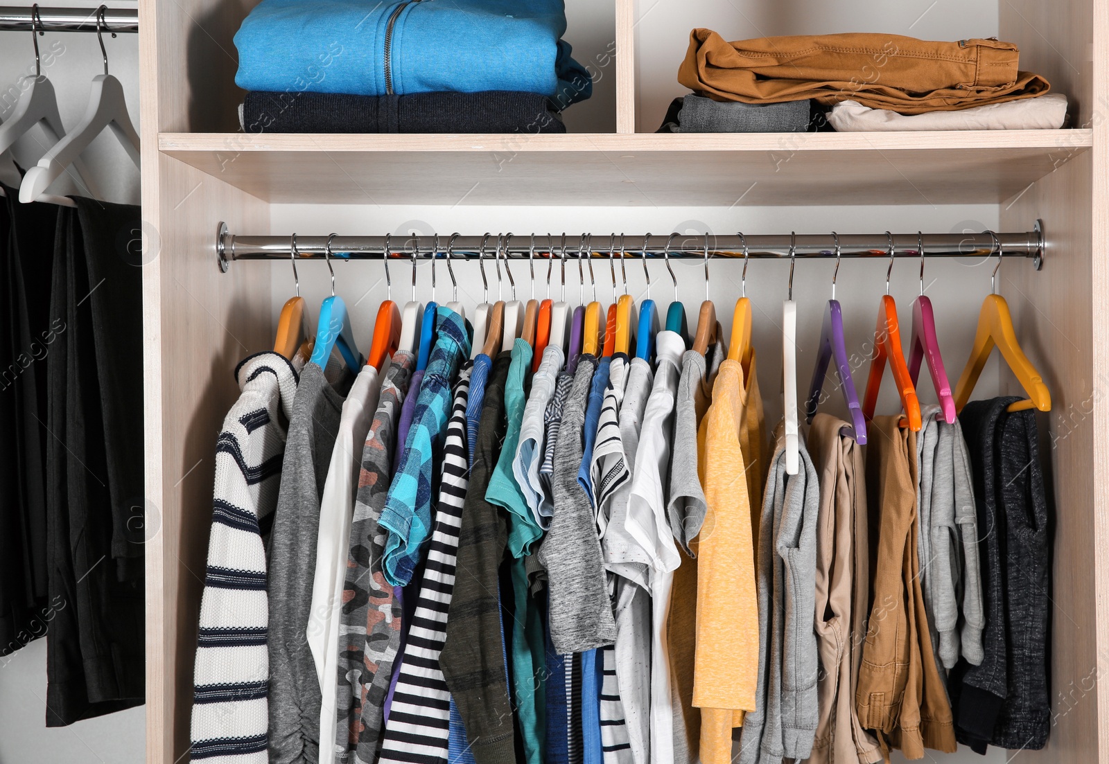 Photo of Wardrobe with stylish boy's clothes hanging on rack