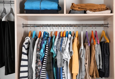 Wardrobe with stylish boy's clothes hanging on rack