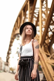 Young woman with camera on city street