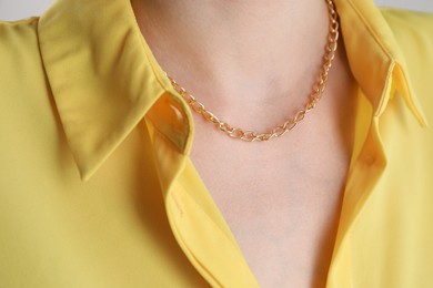 Photo of Closeup view of woman wearing metal chain. Luxury jewelry