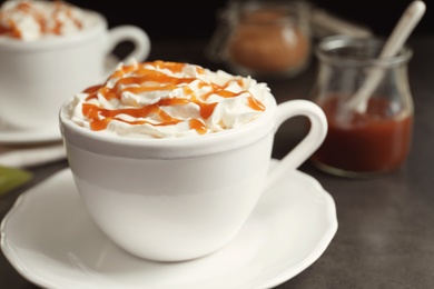 Cup of coffee with caramel topping on table