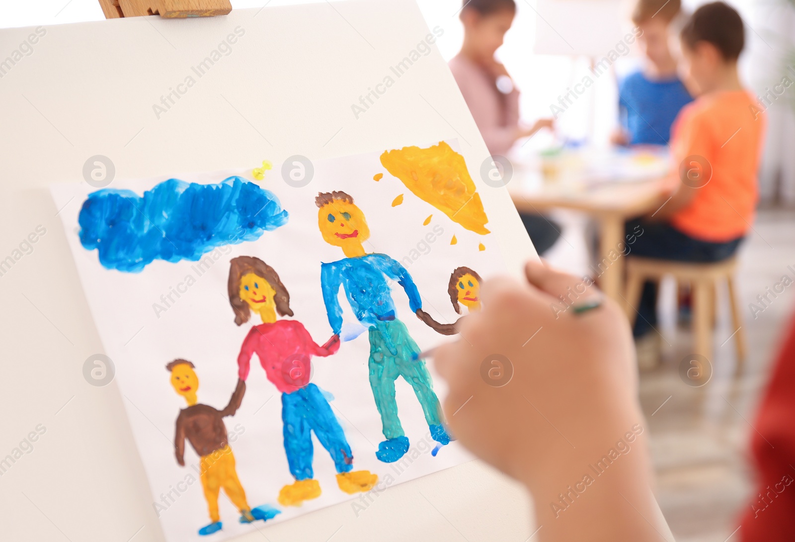 Photo of Little child painting family indoors, closeup view