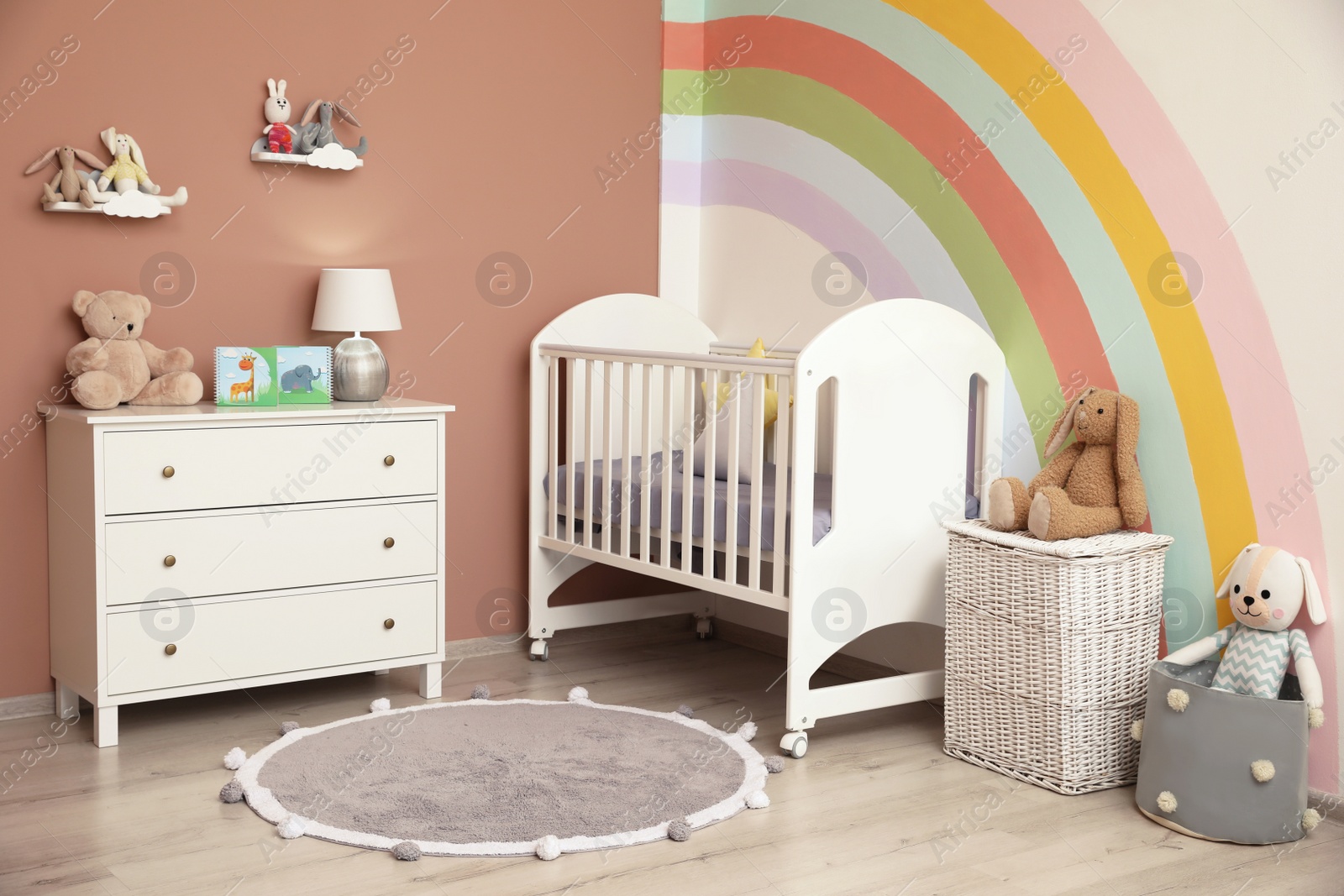 Photo of Cute child's room interior with beautiful rainbow painted on wall