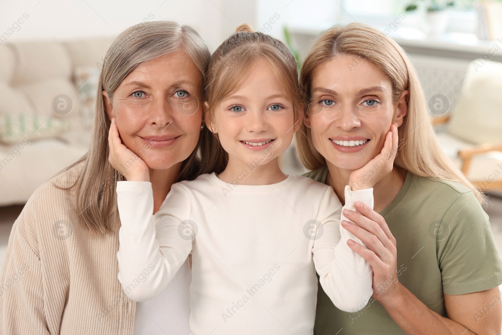 Photo of Three generations. Happy grandmother, her daughter and granddaughter at home