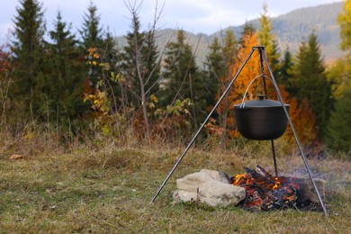 Cooking food on campfire near forest. Camping season