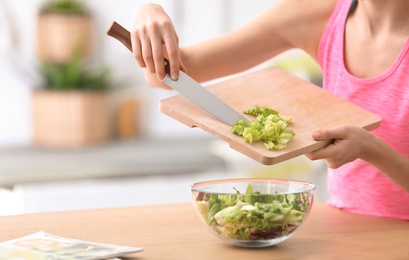 Photo of Young woman in fitness clothes preparing healthy breakfast at home, closeup
