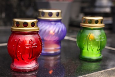 Photo of Different grave lanterns on granite surface at cemetery