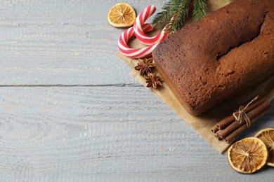 Photo of Delicious gingerbread cake, ingredients and Christmas items on wooden table, flat lay. Space for text