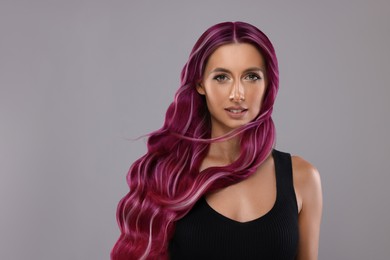 Image of Hair styling. Gorgeous woman with colorful hair on grey background