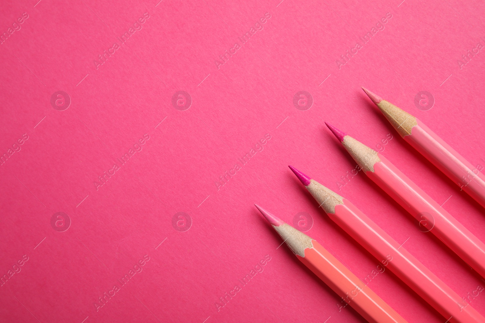 Photo of Flat lay composition with color pencils on pink background. Space for text