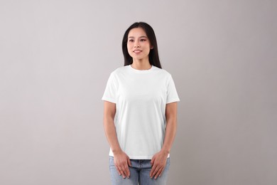 Photo of Woman wearing white t-shirt on light grey background