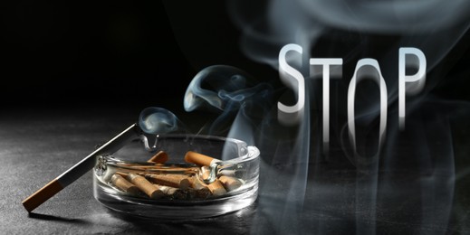 Image of Quit smoking. Word Stop of smoke, ashtray with stubs and smoldering cigarette on table against black background, banner design