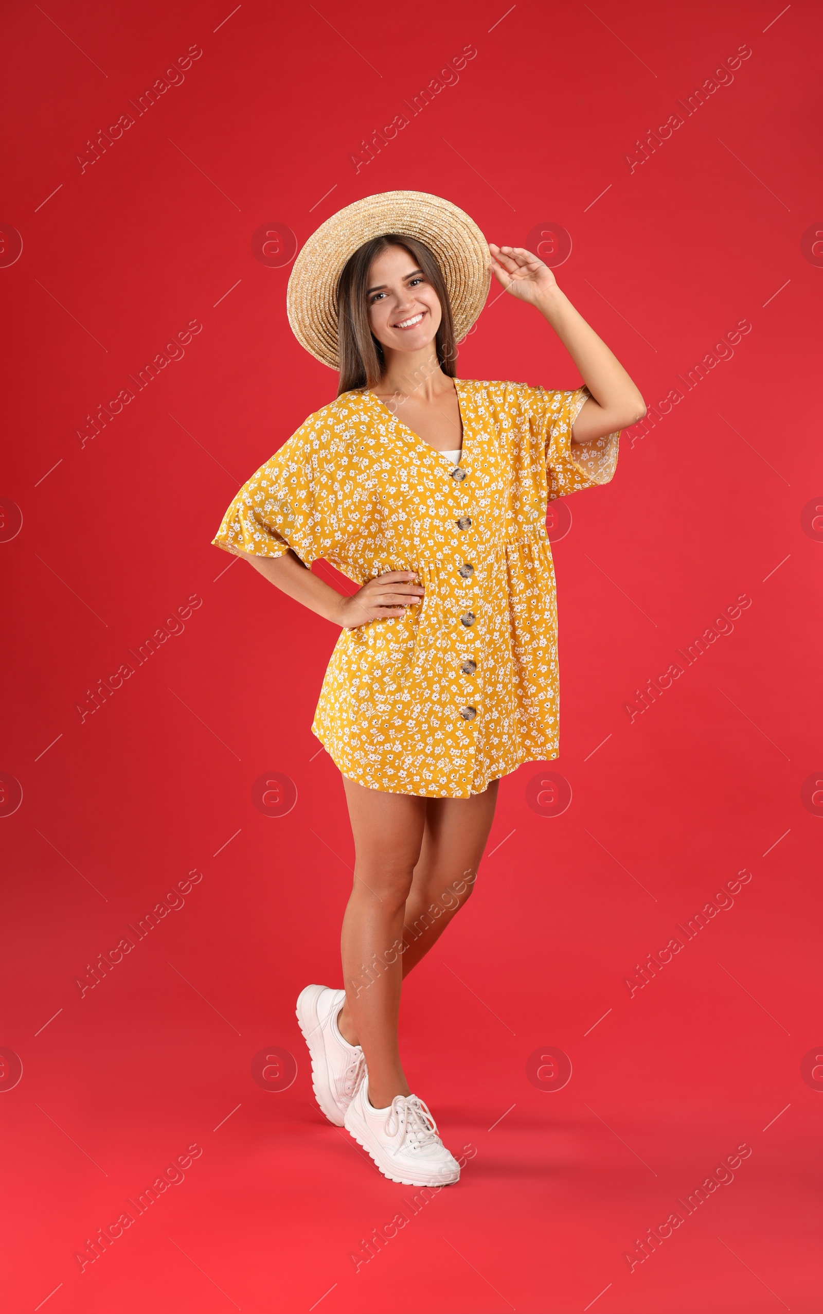 Photo of Young woman wearing stylish yellow dress on red background