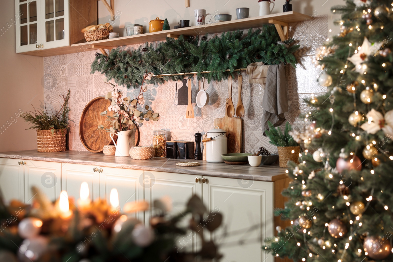 Photo of Stylish kitchen with festive decor and Christmas garland. Interior design