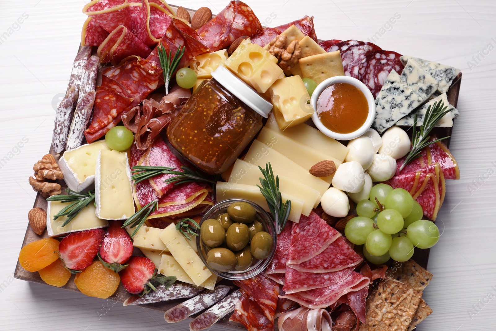 Photo of Assorted appetizers served on white wooden table, top view