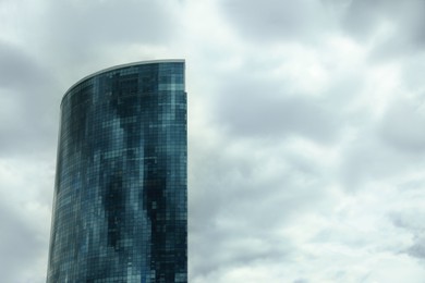 Photo of Modern big building against cloudy sky. Urban architecture