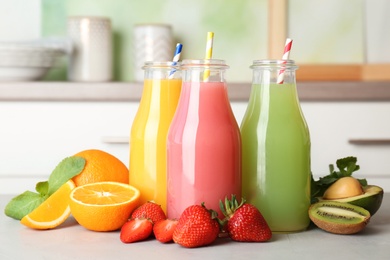 Bottles with tasty juices and ingredients on table