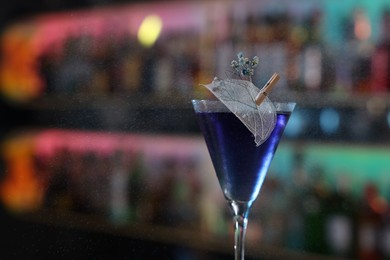 Photo of Fresh alcoholic cocktail in glass against blurred background, closeup. Space for text