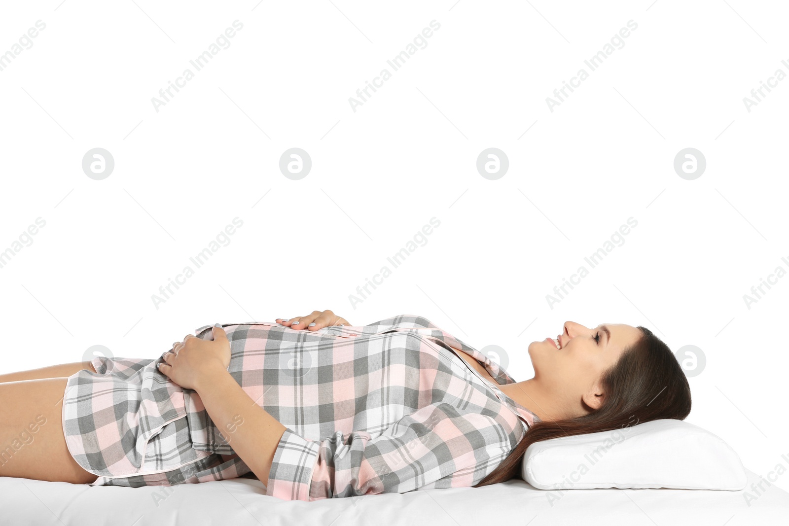 Photo of Beautiful pregnant woman lying with orthopedic pillow on bed against white background