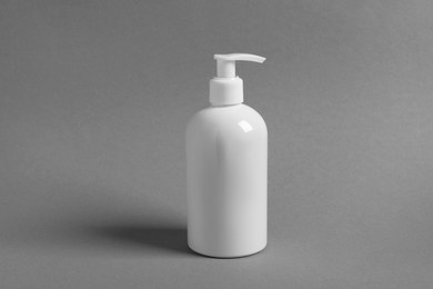 Photo of Bottle with cosmetic product on grey background