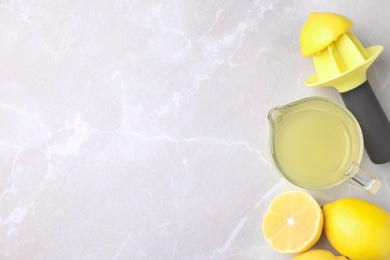 Flat lay composition with freshly squeezed lemon juice on light table. Space for text