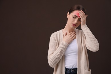 Image of Woman suffering from headache on brown background, space for text. Cold symptoms