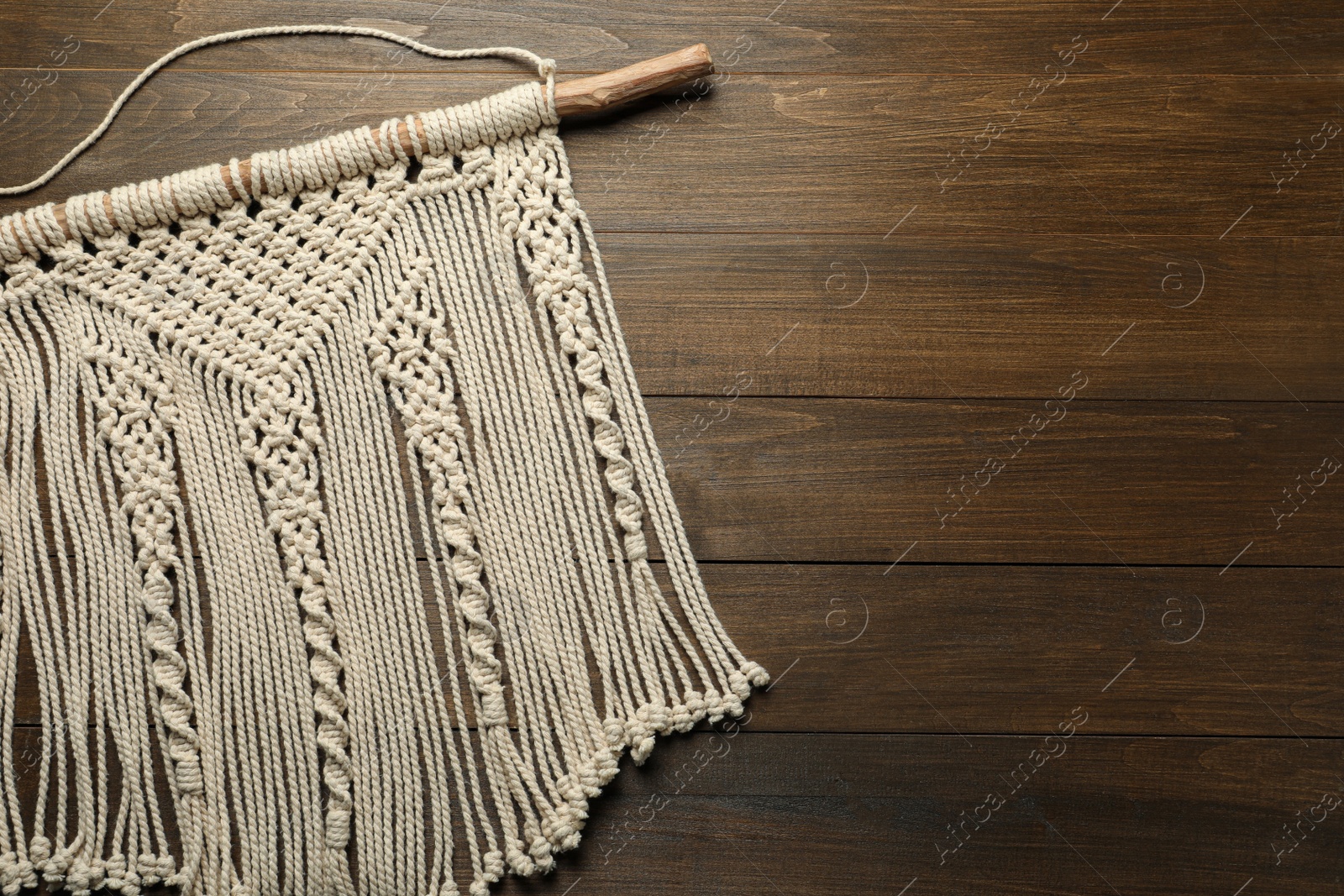 Photo of Stylish beige macrame on wooden table, top view. Space for text