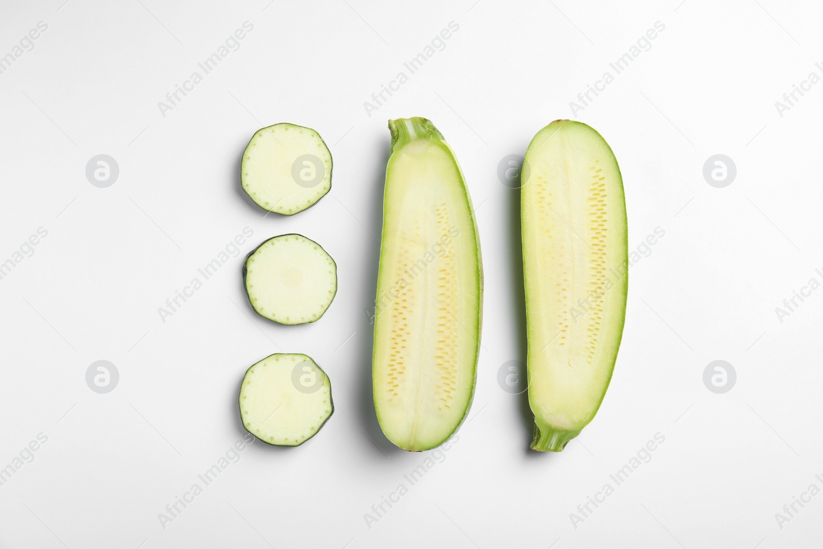 Photo of Fresh ripe cut zucchinis on white background, top view