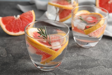 Glasses of infused water with grapefruit slices on table