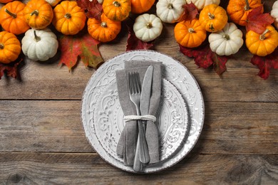 Photo of Happy Thanksgiving day. Beautiful table setting, autumn leaves and pumpkins on wooden background, flat lay