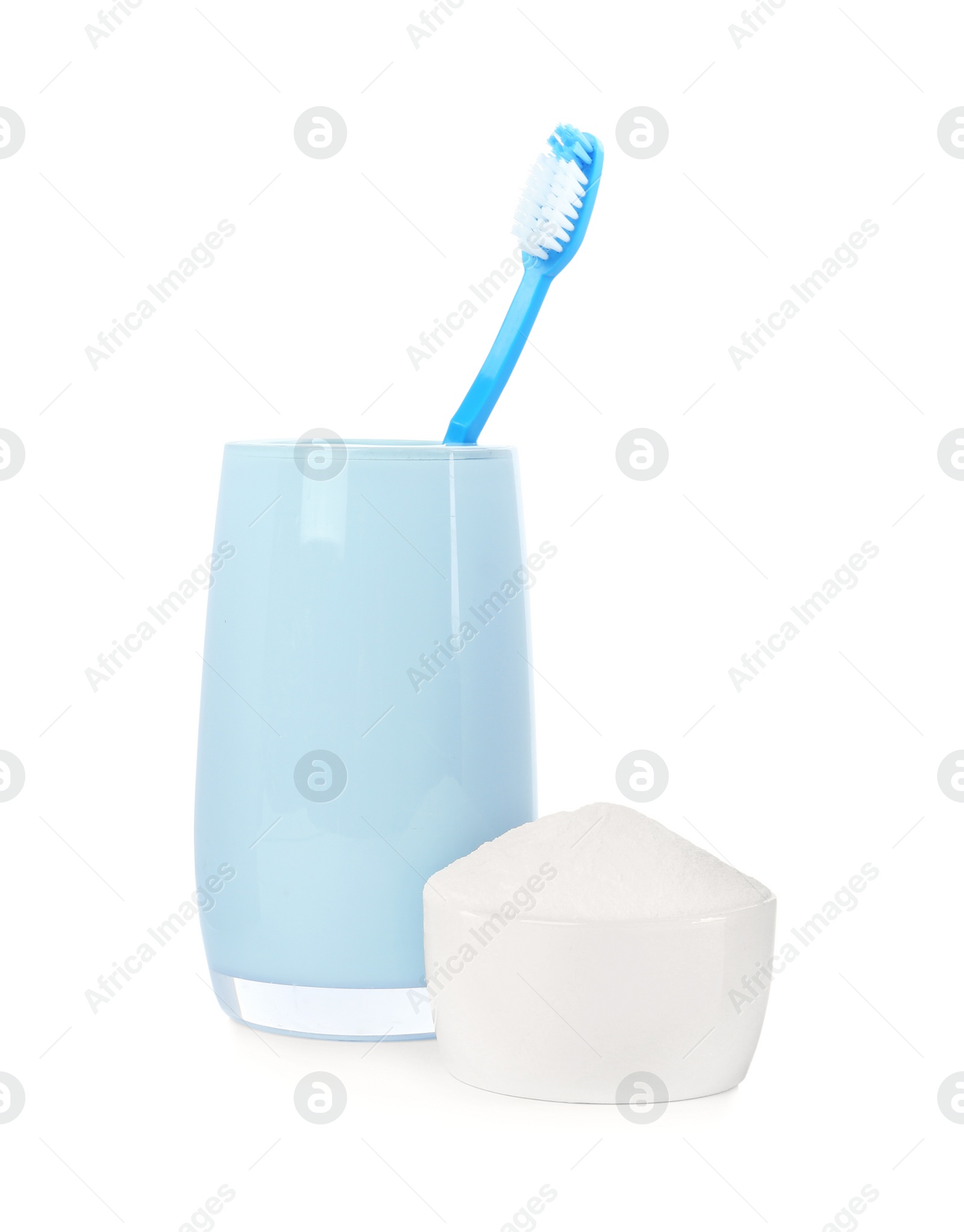 Photo of Toothbrush in holder and bowl with baking soda on white background