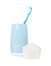 Toothbrush in holder and bowl with baking soda on white background