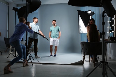 Photo of Professional team working with model in photo studio