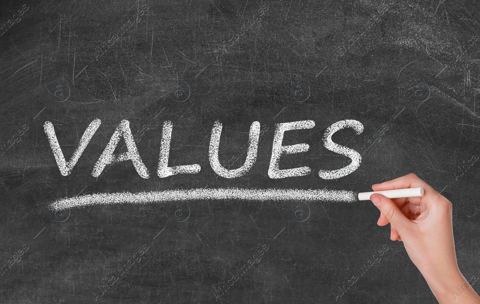 Image of Woman writing word VALUES on blackboard, closeup