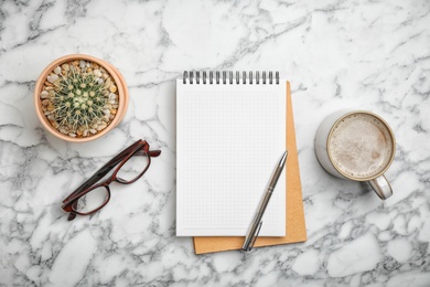 Photo of Flat lay composition with notebook and cup of aromatic coffee on marble background