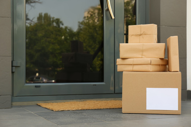 Photo of Cardboard boxes near door. Parcel delivery service