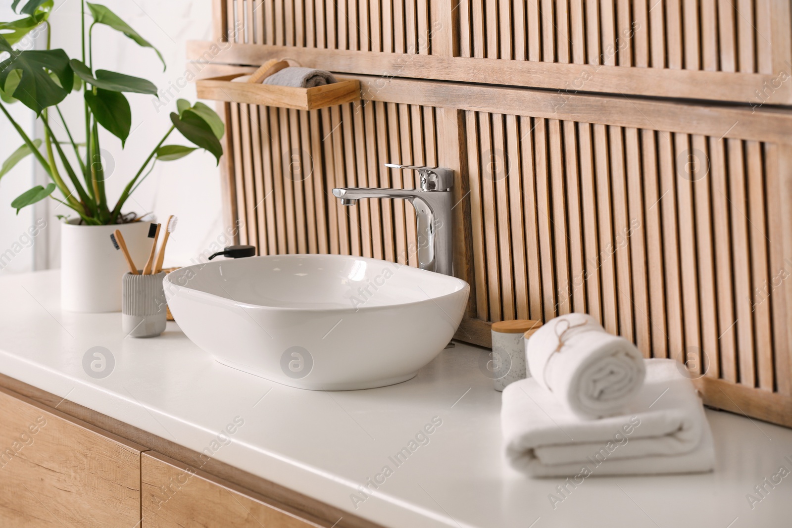 Photo of Stylish vessel sink near wooden wall in modern bathroom